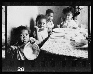 18.-African-American-children-seated-around-a-table-in-an-apartment-eating