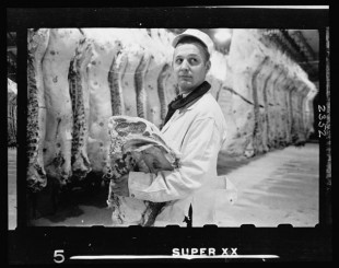 20.-Butcher-holding-slab-of-beef-in-a-meat-locker