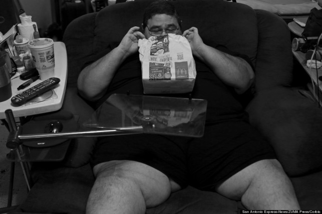 22 Sep 2014, San Antonio, Texas, USA --- Sep 22, 2014 - San Antonio - Confined to his chair and house again, HECTOR GARCIA JR. peeks into a bag holding a 20-piece box of Chicken McNuggets brought to him by his mother in September 2014. Mondays were always 'cheat days' while dieting, but in recent months Garcia admitted that most days had become cheat days as his motivation to lose weight dwindled. (Credit Image: © Lisa Krantz/San Antonio Express-News) --- Image by © Lisa Krantz/ZUMA Press/Corbis
